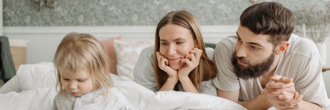 A loving family of three enjoying time together in a peaceful bedroom setting.
